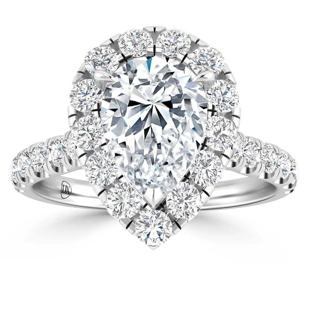 A pear-shaped diamond ring with a halo and band of round diamonds set in white metal.