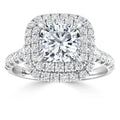 A cushion-cut diamond ring with double halo and pavé-set diamonds on a white gold band.