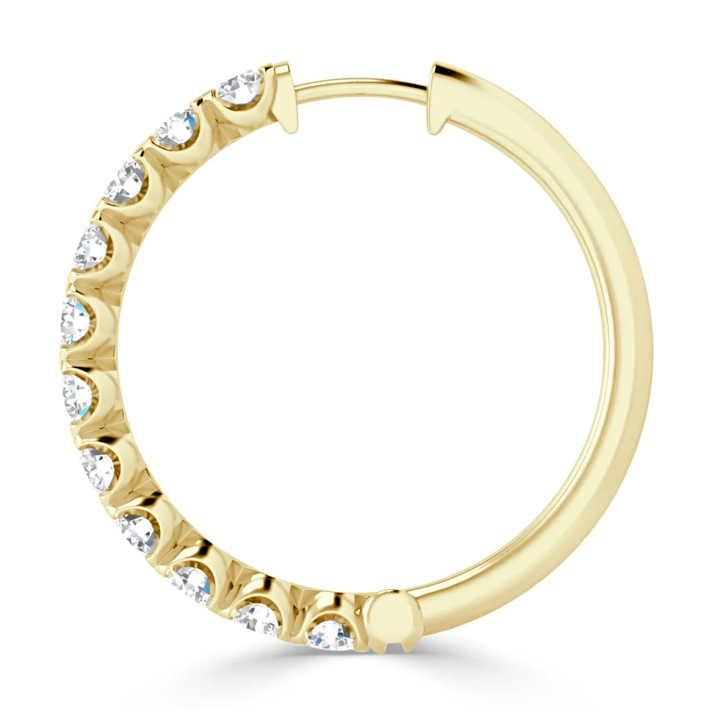 Gold hoop earring with embedded white gemstones along one half of the circular band, on a white background.