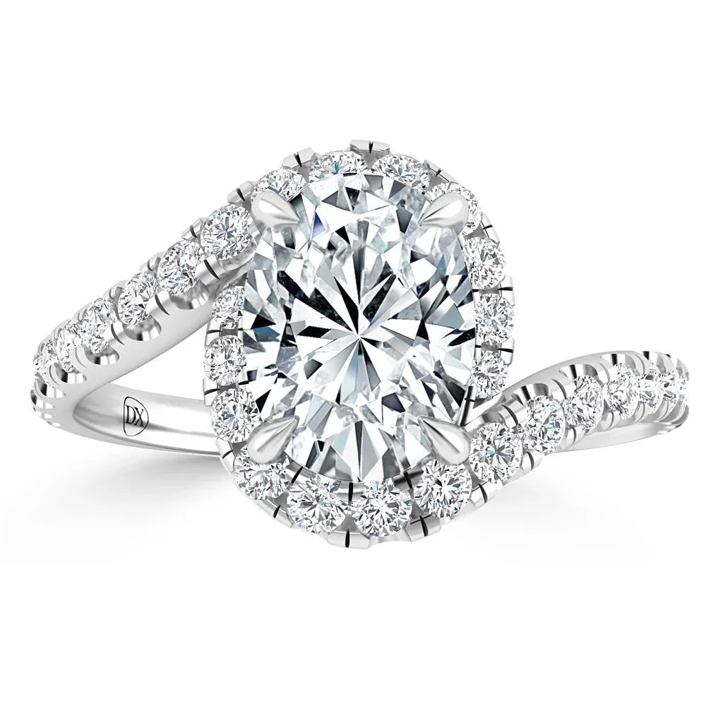 An oval diamond ring with a split shank, halo setting, and pavé diamonds on a white gold band.