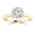 A gold band solitaire ring with a large round diamond set in a four-prong white gold setting.