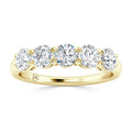 A gold ring with five round, sparkling diamonds set in a row along the top of the band.