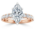 Rose gold ring with a large marquise-cut diamond and smaller round diamonds on the band, shown on white background.
