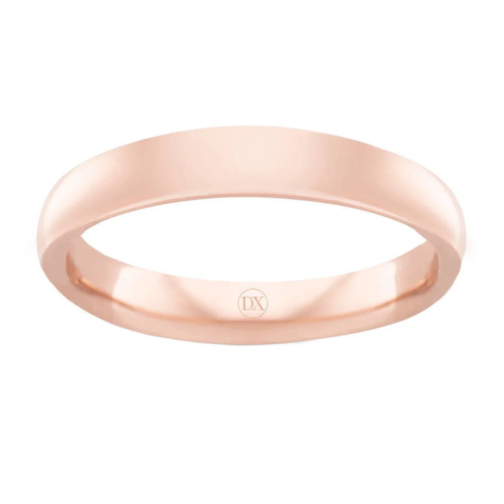 A simple, polished rose gold ring with a smooth surface and DX engraved on the inner band.