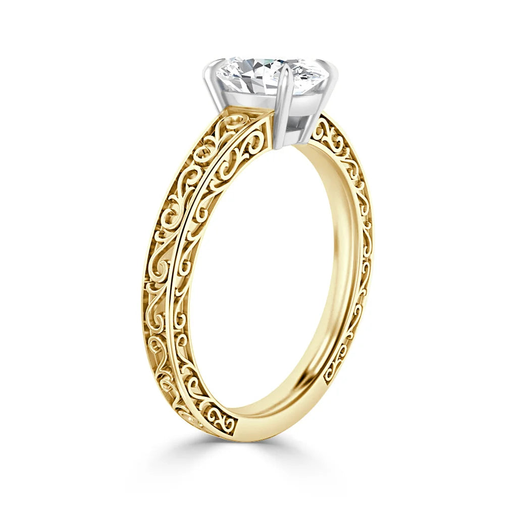 Gold ring with ornate filigree band and a large round diamond in a white gold prong setting.