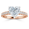 Rose gold ring with a large heart-shaped diamond and small diamonds set along the band.