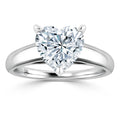 A silver ring with a large heart-shaped diamond solitaire set in a prong setting on a plain band.
