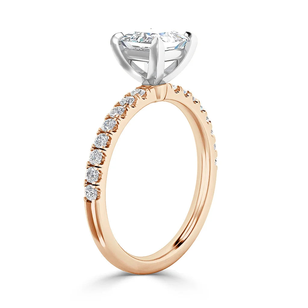 Rose gold ring with small diamonds on the band and a large round diamond in a white gold prong setting.