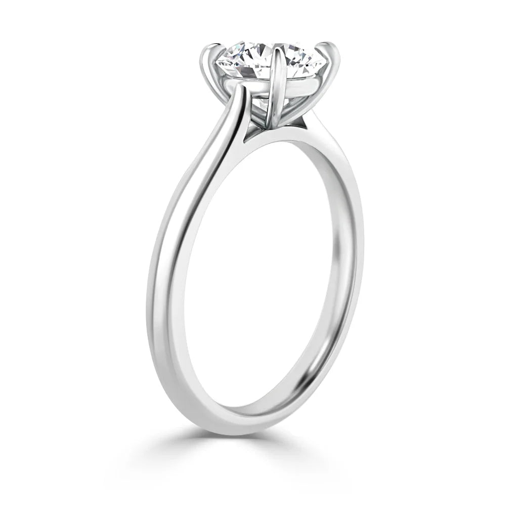 Side view of a solitaire engagement ring with a round diamond set in a six-prong white gold band.