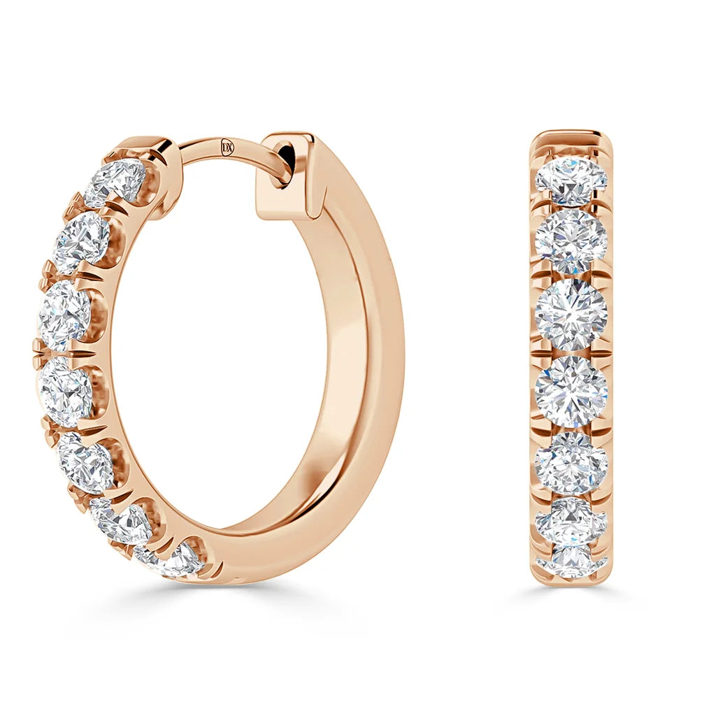 Rose gold hoop earrings set with seven round, sparkling white diamonds on the front outer edge of each hoop.