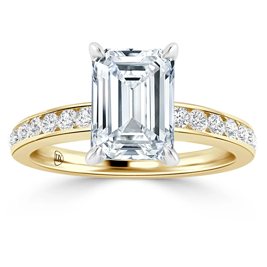 Emerald-cut diamond ring with gold band and round side diamonds set along the upper half of the band.