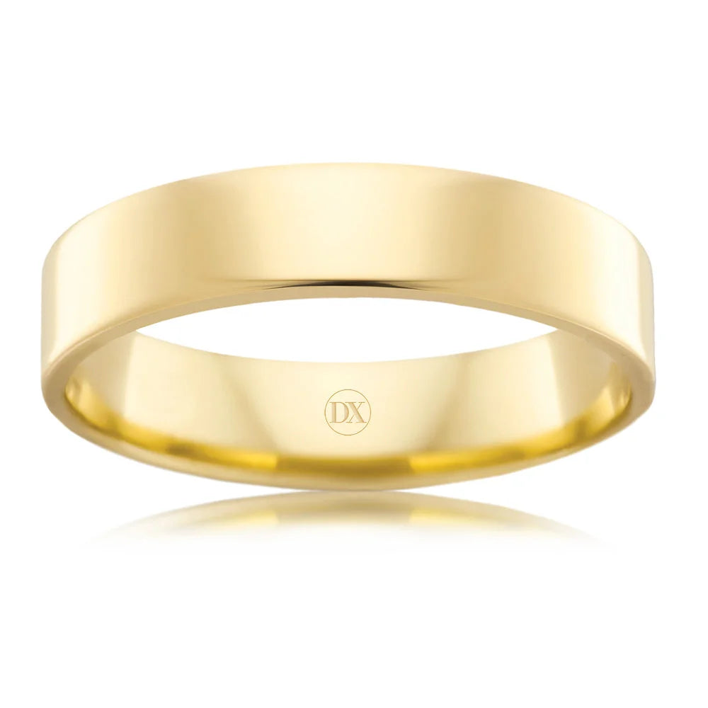 Simple, polished yellow gold wedding band with a flat surface and a small DX engraving inside.