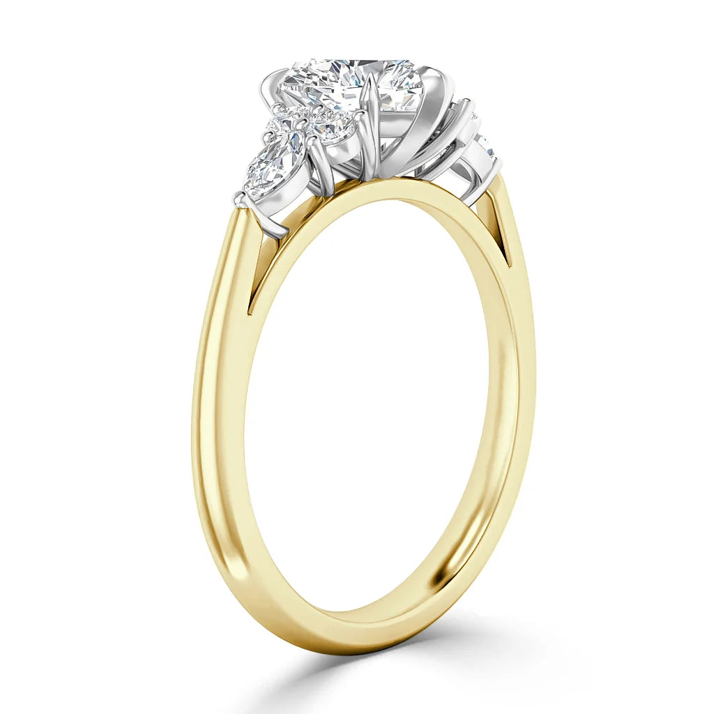 Gold ring with a round center diamond and two side diamonds set in a white metal prong setting.