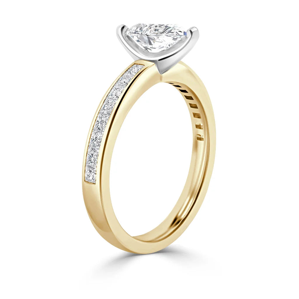 A gold ring with a teardrop-shaped diamond and small diamonds set along the band.