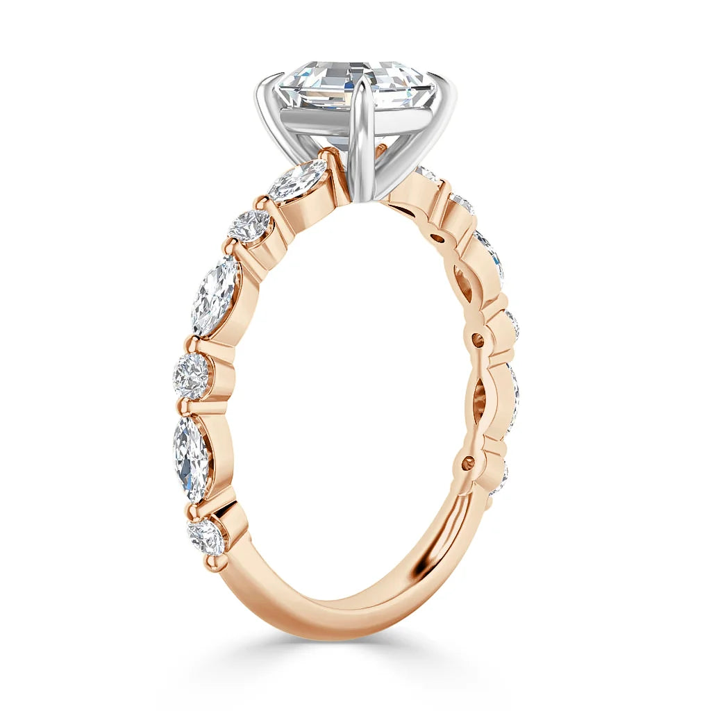 A rose gold ring with oval side diamonds and a large round center diamond set in a white gold prong setting.