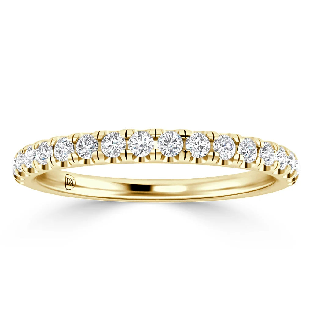 A thin yellow gold ring with a row of round white diamonds set along the top half of the band.