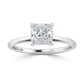 A solitaire ring with a princess-cut diamond set on a simple, polished white gold band.