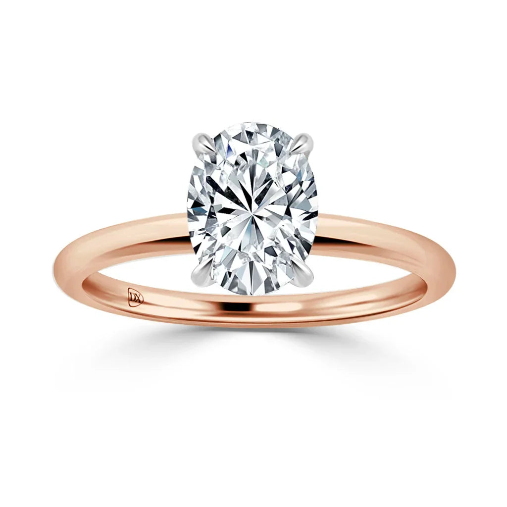 A rose gold ring with a large oval-cut diamond solitaire set in a four-prong setting on a plain band.