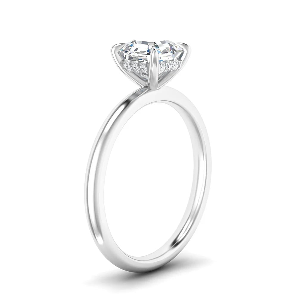 A white gold engagement ring with a round solitaire diamond in a prong setting, viewed from the side.