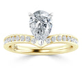 A pear-shaped diamond ring with a gold band featuring small round diamonds set along the band.