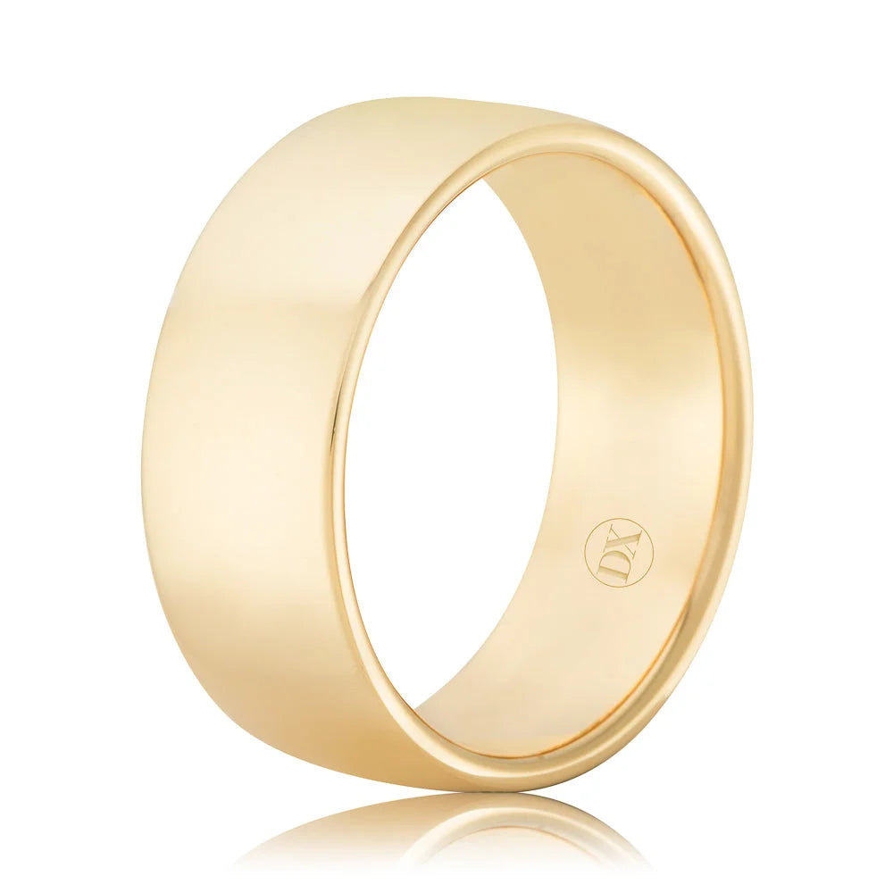 A plain, wide yellow gold band ring with a smooth, polished finish and a small engraved logo inside.