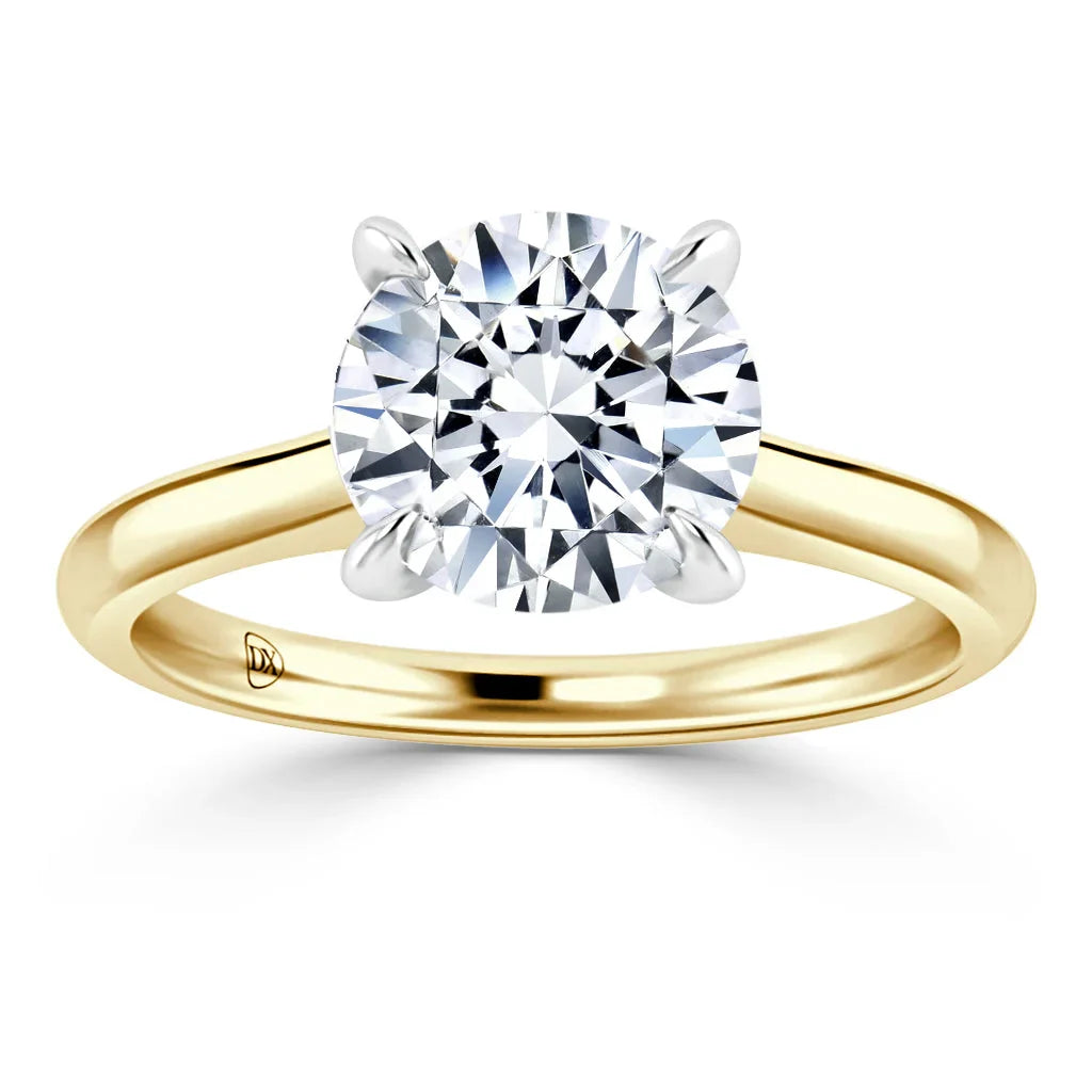 A gold solitaire ring with a round brilliant-cut diamond held by four prongs on a plain band.